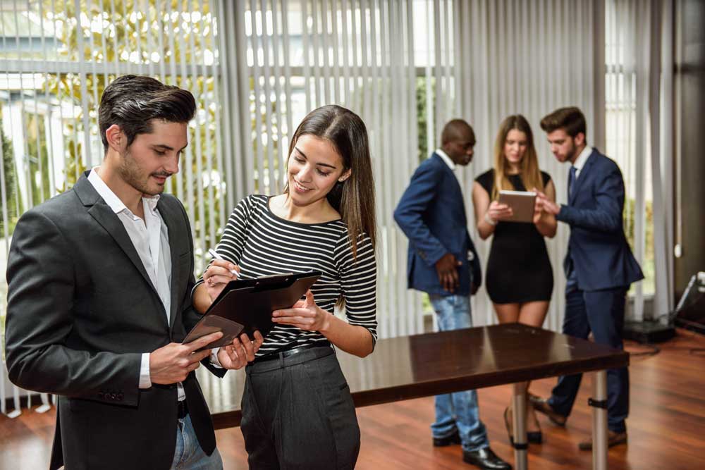 Grupo de empresarios en oficina conversando entre sí. Jinete y Asociados