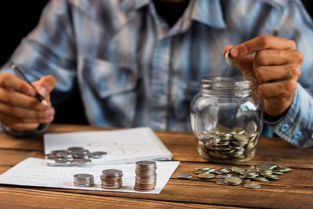 Imagen de persona contando monedas y haciendo cuentas. Jinete y Asociados